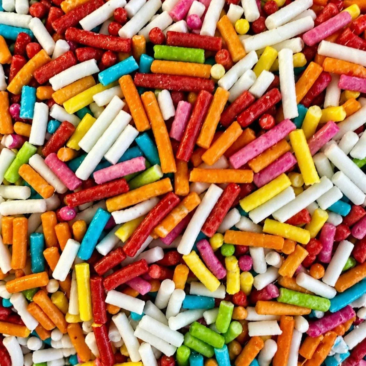 Posypka cukrowa tęczowa Posypka cukrowa tęczowa. Chrupiące pałeczki cukrowej posypki w tęczowej mieszance żywych kolorów. Ożywiają gałki lodów, lody włoskie, gofry, ciasta i desery w pucharkach. Sypka, łatwa w dozowaniu, świetnie widoczna na każdej polewie. Skład: cukier, tłuszcz palmowy, glukoza, barwniki, substancje glazurujące. Produkt może zawierać mleko, jaja, soję.